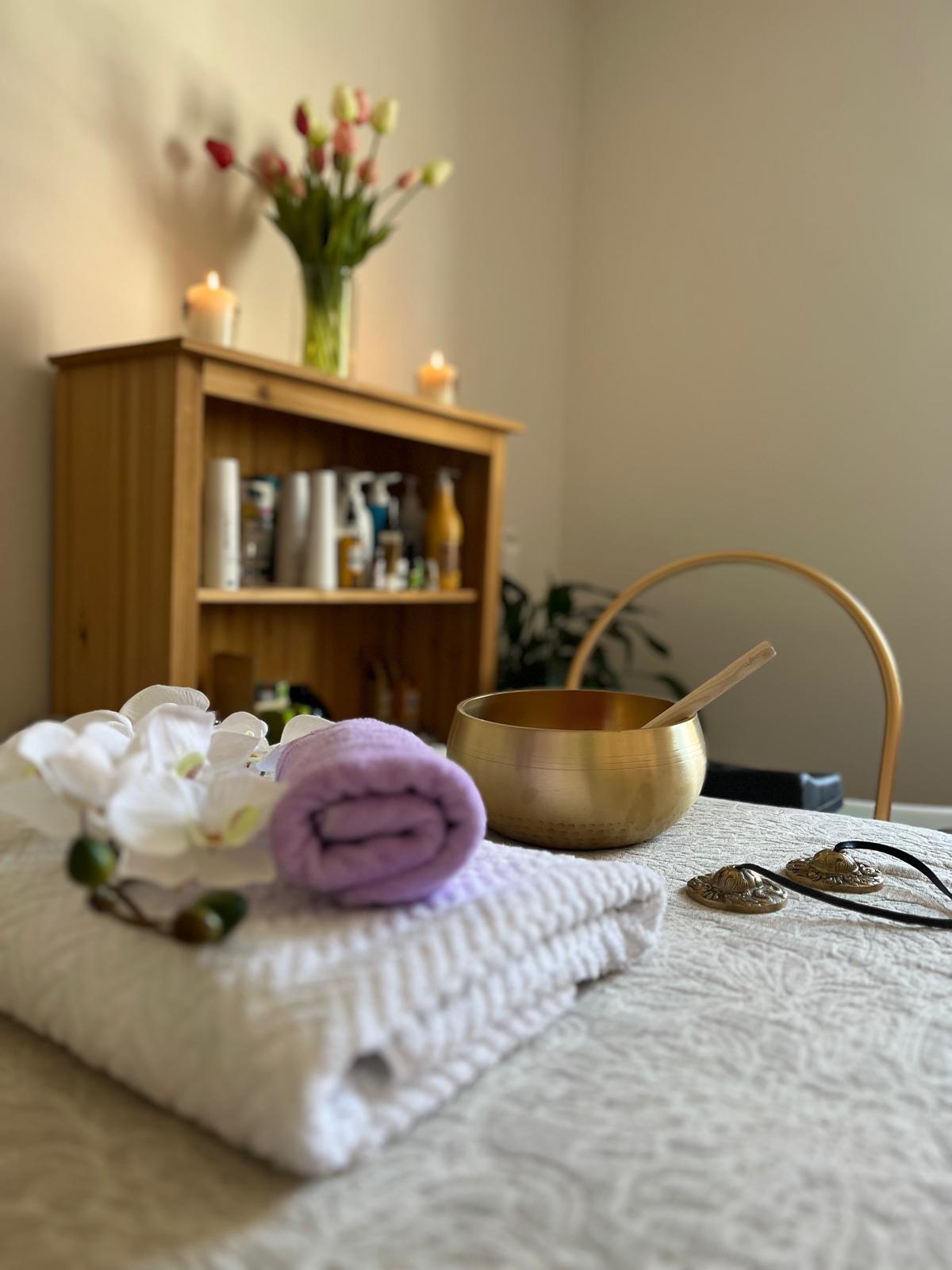 Klangschale und Orchidee auf der Behandlungsliege
